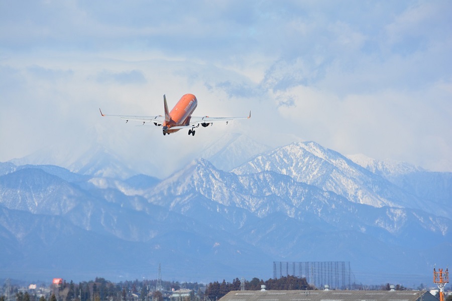 雪が積もる日本アルプスをバックに新千歳空港へ向け離陸するFDA機